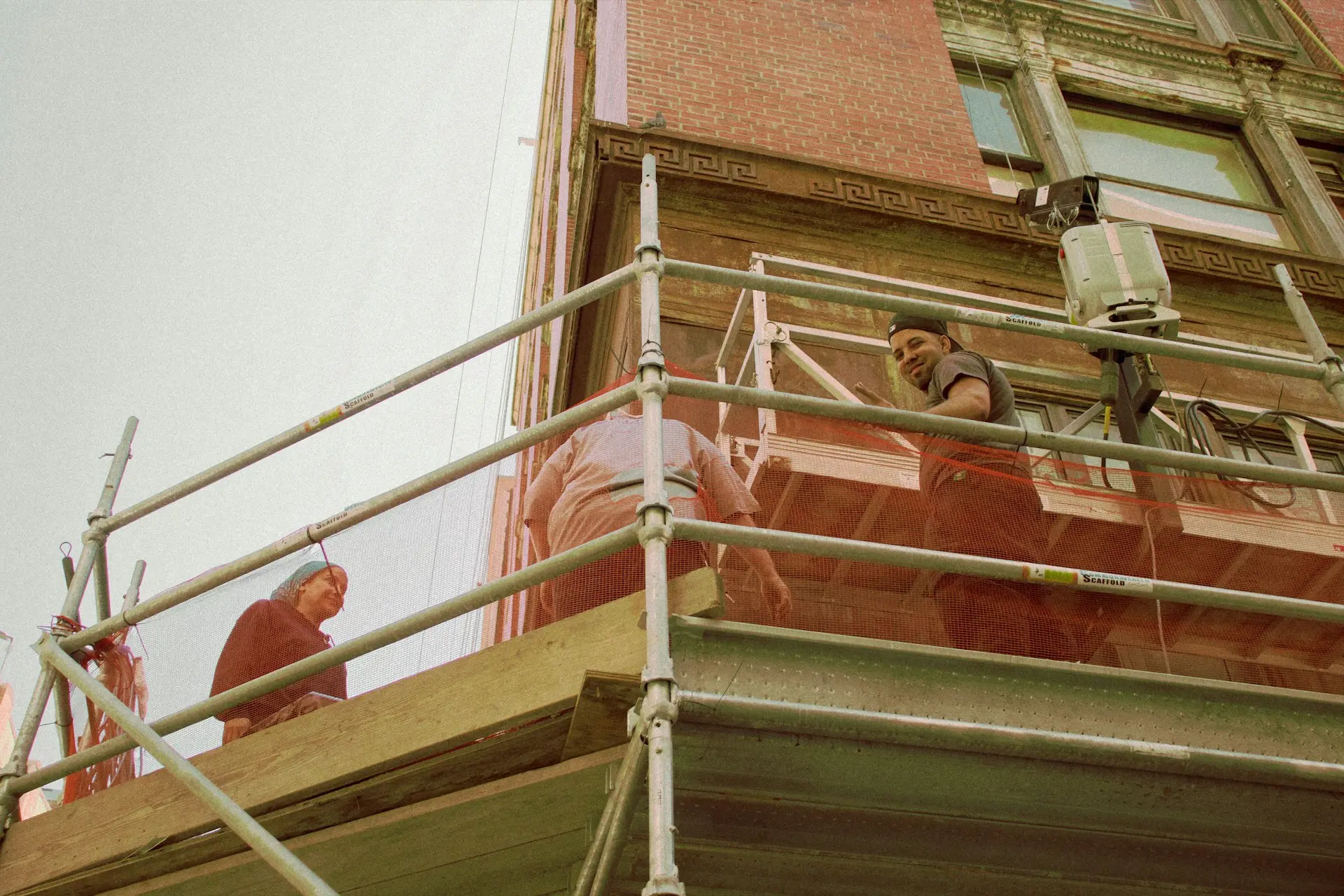woman in red long sleeve shirt and black pants standing on white metal railings during daytime